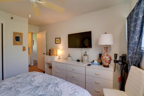 a bedroom with a dresser with a tv on it at Beachside Molokai Condo w/ Lanai & Pool Access! in Kaunakakai