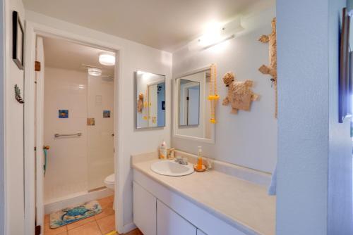 a white bathroom with a sink and a shower at Beachside Molokai Condo w/ Lanai & Pool Access! in Kaunakakai