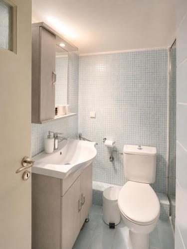 a bathroom with a white toilet and a sink at Farniente Tolo in Tolo