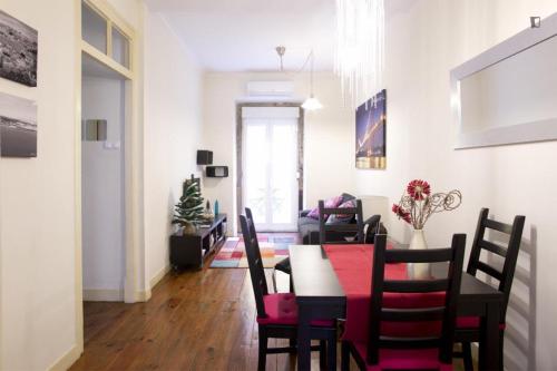 a dining room and living room with a table and chairs at Find Me Inn Alcantara in Lisbon