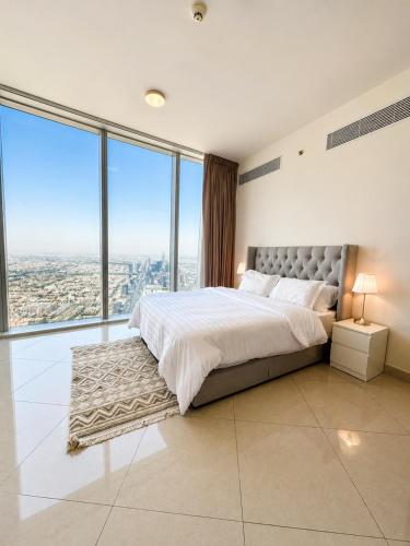 a bedroom with a large bed and large windows at شقة برج رافال Rafal Tower in Riyadh
