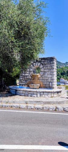 a stone fountain on the side of a road at L'olivier de Jeanine in Contes