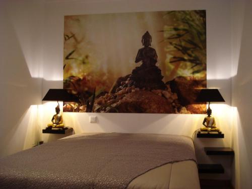 a bedroom with a bed with a painting on the wall at Stone House in Sabugueiro