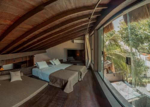 a bedroom with a bed and a large window at Vila Torém in Icaraí