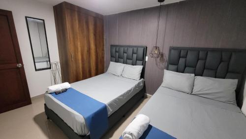 two beds in a small room with two beds sidx sidx sidx at Estudio cerca a puerta del norte in Bello