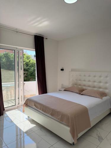 a bedroom with a large bed and a large window at Duraku Apartments in Ulcinj