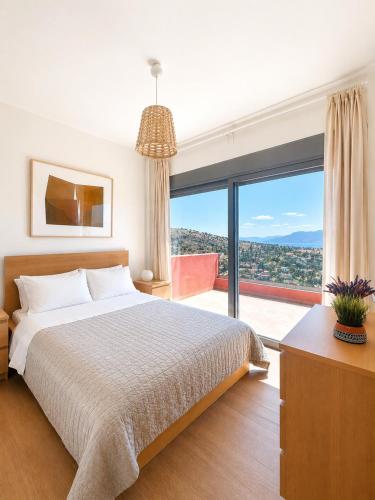 a bedroom with a bed and a large window at Villa Harmonia in Egina