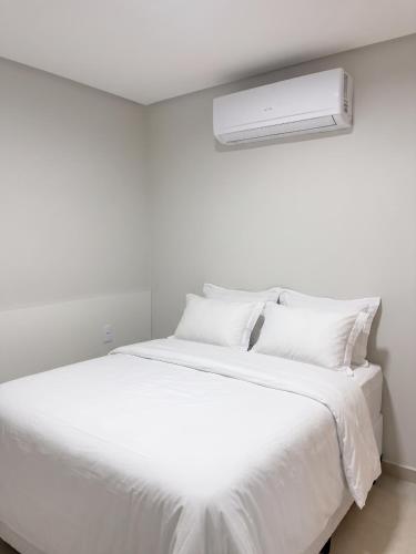 a white bed with white sheets and pillows at Laguna Sun Set in Salinópolis
