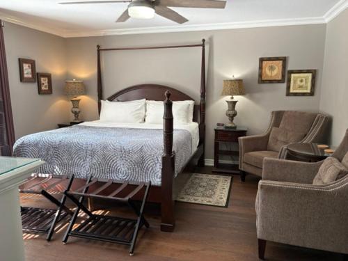 a bedroom with a bed and a couch and a chair at Casa Blanca Boutique Bed & Breakfast in Niagara-on-the-Lake