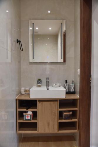 a bathroom with a sink and a mirror at Nook Athens Airport in Spata