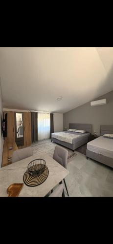 a large room with two beds and a table at Sea&Forest view in Buljarica