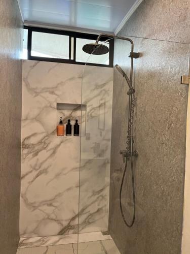 a shower with a glass door in a bathroom at Altima Arenal Volcano View in Tanque
