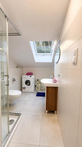a bathroom with a sink and a washing machine at Apartament Premium Cichowo in Cichowo