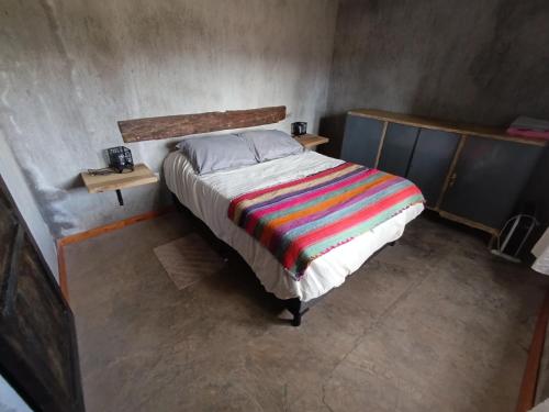 a bedroom with a bed with a colorful blanket at Tierra Potrerillos in Potrerillos