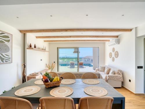 a living room with a dining room table and chairs at Villa Dioni in Kardamaina