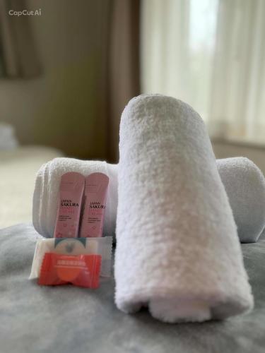 a towel and toothbrushes sitting on a bed at Cosy on Goldfinch in Ohakune