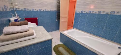 a blue bathroom with a tub and a sink at Appartement Alger in Alger
