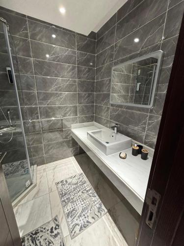 a bathroom with a sink and a shower and a mirror at New Alamen Towers in El Alamein