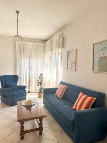 a living room with a blue couch and a table at Lido di Camaiore-Spacious & Bright 2Bedrooms House in Lido di Camaiore