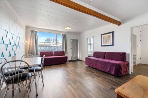 a living room with a purple couch and a table at Bings Motel in Blenheim