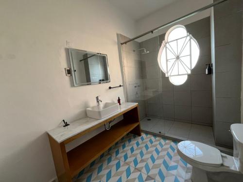 a bathroom with a sink and a shower and a toilet at Departamento 101 Casona Catalina in Puebla