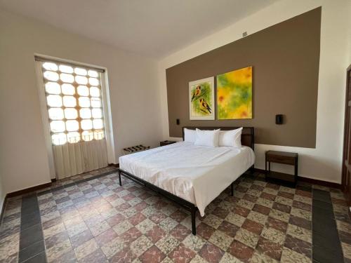 a bedroom with a white bed and a window at Departamento 101 Casona Catalina in Puebla