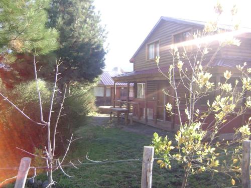 a yard next to a house with a picnic table at Cabañas El Puente Azul in Aluminé