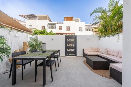 a patio with a table and chairs and a couch at Villa Cobo in Torremolinos