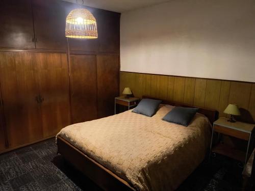 a bedroom with a bed and a chandelier at La Oliva in San Martín