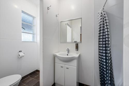 a white bathroom with a sink and a toilet at Bings Motel in Blenheim