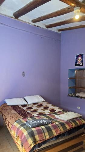 a bedroom with a bed in a purple wall at Pisac cosmic in Pisac