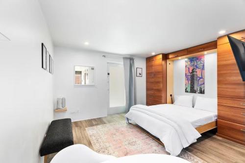 a bedroom with a large white bed and wooden walls at DTPH Cozy Corner - Pool & Parking in Phoenix