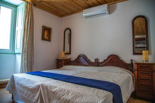 a bedroom with a large bed and a window at Casa do Arco da Vila in Faro
