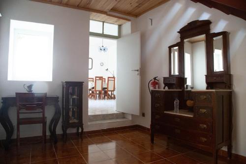 a room with a dresser and a mirror and a table at Casa do Arco da Vila in Faro