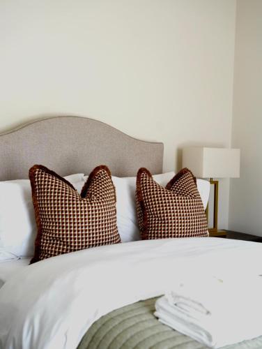 a white bed with two pillows and a headboard at Carland Cottage in Carland