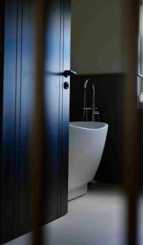 a white sink in a bathroom with a black wall at Carland Cottage in Carland