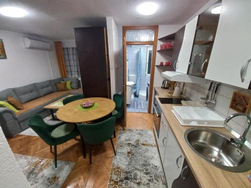 a kitchen and living room with a table and a couch at Apartment Meri with garage in Velika Kladuša
