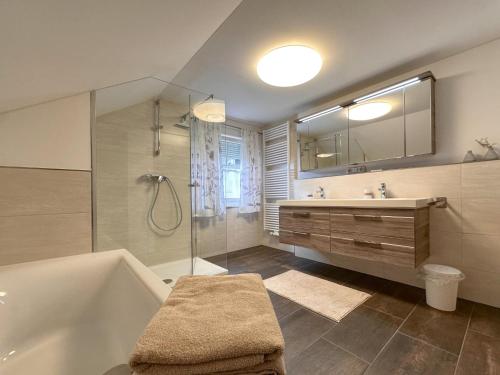 a bathroom with a tub and a sink and a mirror at Bayerischer Wald in Waldkirchen