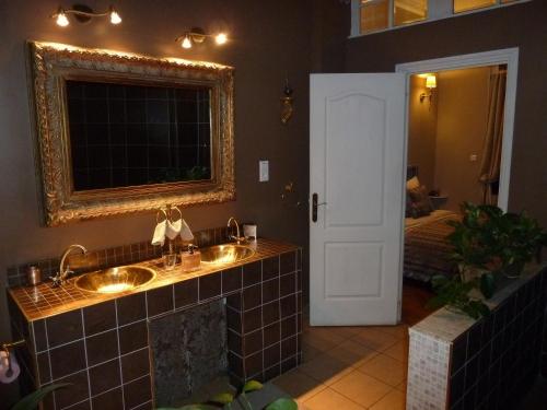 Baño con 2 lavabos y espejo en New West Room en La Madeleine