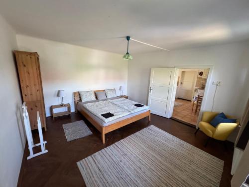 a bedroom with a bed and a living room at Čejkovický domek in Čejkovice