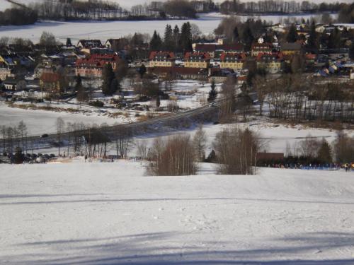 a snow covered city with a town in the distance at Apartmány Eva Frymburk in Frymburk