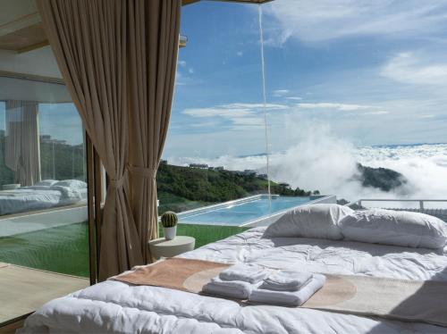 a bedroom with a bed and a view of a pool at รีทรีท ภูทับเบิก in Ban Maeo Thap Boek