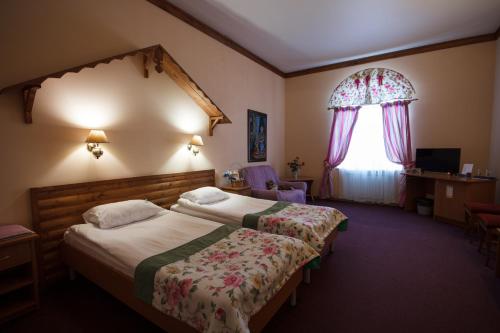 um quarto de hotel com duas camas e uma janela em Koshkin Dom em Myshkin