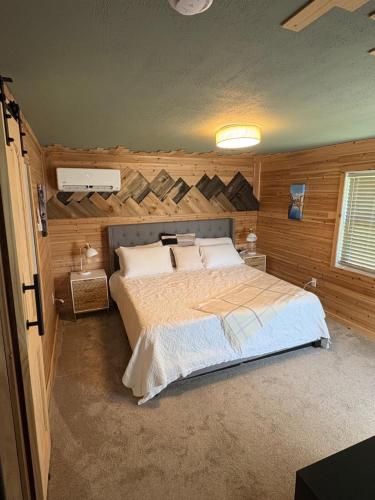 a bedroom with a bed with a wooden wall at The Perfect Match River Retreat in Buffalo City