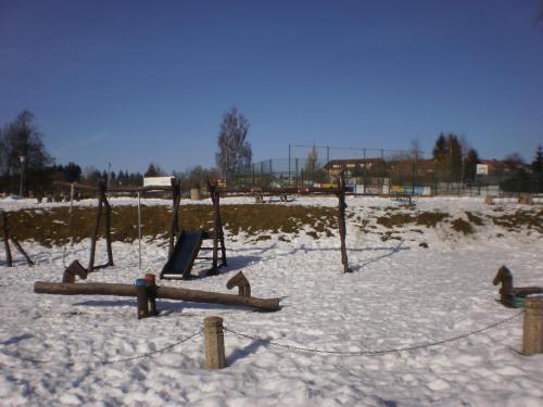 a playground covered in snow in a park at Apartmány Eva Frymburk in Frymburk