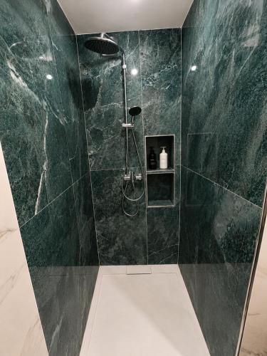 a bathroom with a shower with green marble walls at Nour House Imi Ouaddar in Agadir nʼ Aït Sa