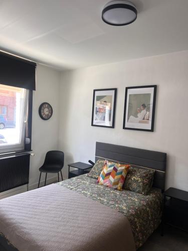 a bedroom with a bed and two pictures on the wall at Studio 156 in Boussu
