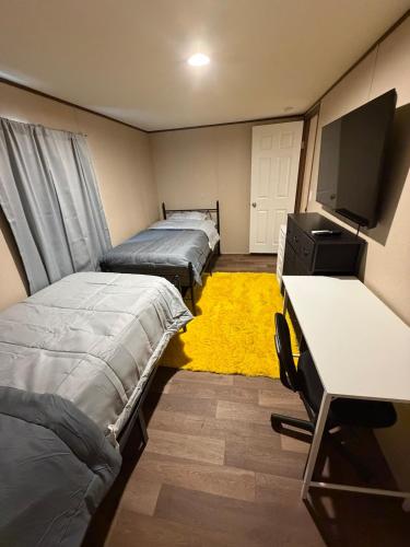 a room with three beds and a desk and a tv at The Relaxation Haven in McRae