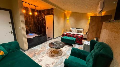 a living room with a green couch and a bed at Viyana Suite Hotel in Istanbul