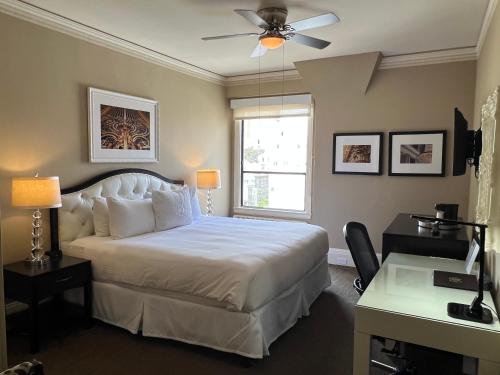 a bedroom with a bed and a desk and a window at Kensington Park Hotel in San Francisco